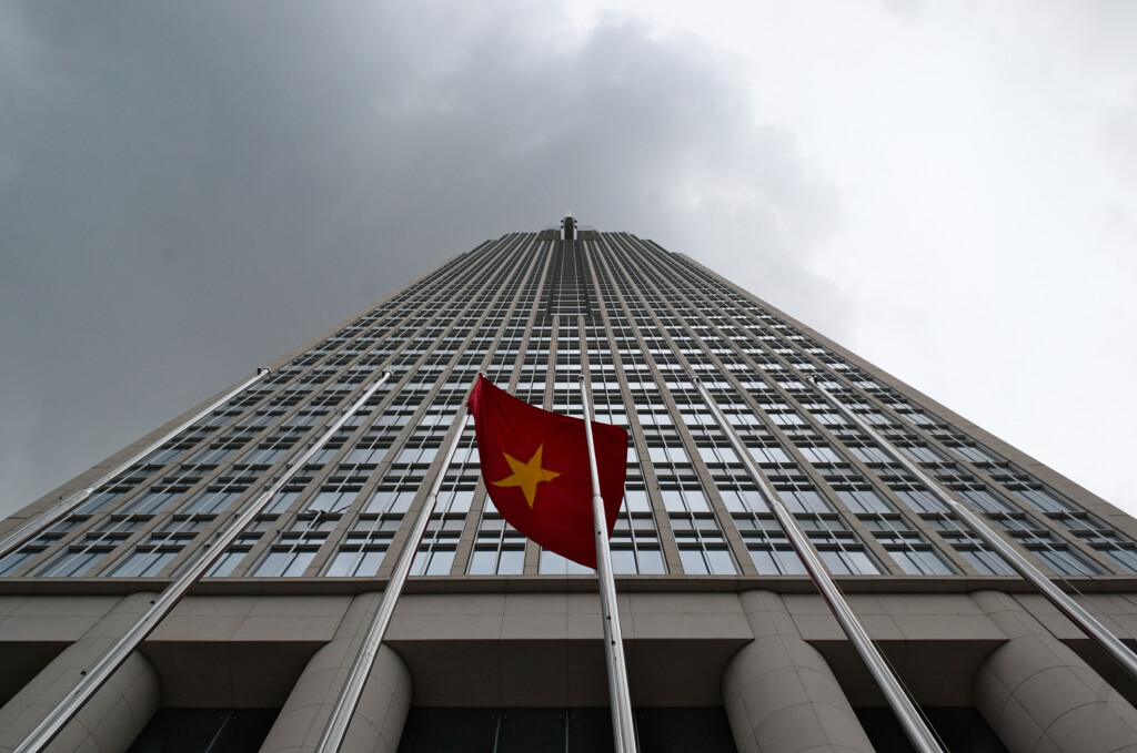 Flag of Vietnam in front of high-rise finance building on the background of cloudy sky, Ho Chi Minh city (Saigon), Vietnam